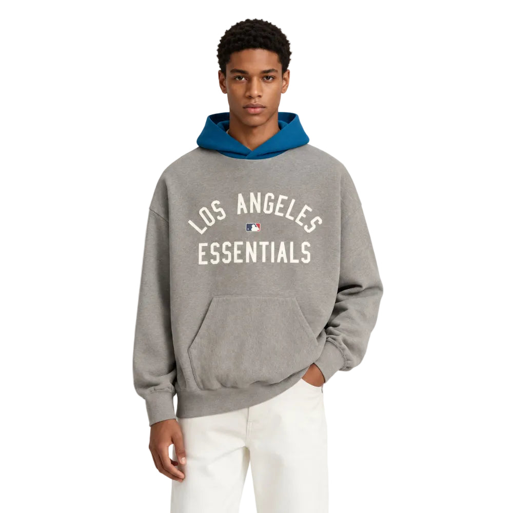 Fear of God Essentials Dodgers Sport Hoodie Concrete Heather Blue Sapphire worn by model from the front