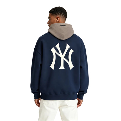 Fear of God Essentials Yankees Sport Hoodie Midnight Navy Homestead Heather shown on model from the back