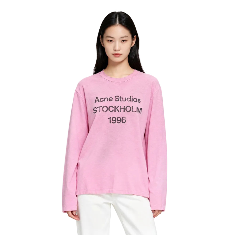 Model wearing Acne Studios Sprayed 1996 Logo T Shirt in Cotton Candy Pink – front view highlighting the 1996 logo and relaxed crewneck silhouette